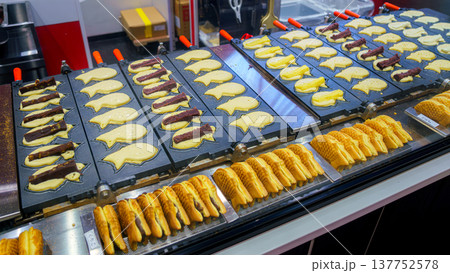 Tokyo, Japan - Oct 14 2024, close-up view of wide cast-iron frying pan with molds used to fry traditional Japanese fish-shaped treats called taiyaki at Tokyo street cafe, without people, Tokyo, Japan 137752578