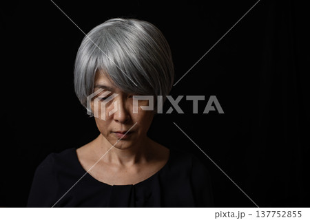寂しそうに目を伏せる白髪のシニア女性 137752855