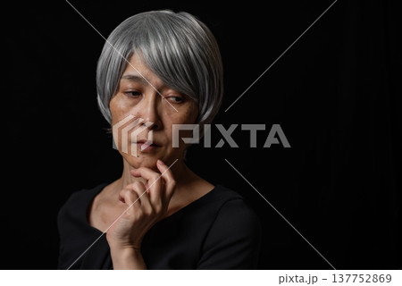 悪だくみをする白髪のシニア女性 137752869