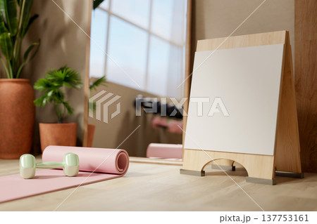 Yoga mat and dumbbell with blank signboard on wooden floor aside mirror in fitness gym exercise room 137753161