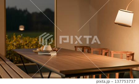 Potted plant on book with breads and coffee on wooden table aside lamp and window in dim dining room 137753737