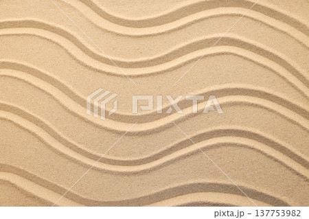 Sand is shaped in wavy lines along a beach area 137753982