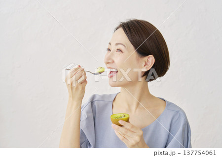 リビングでキウイフルーツを食べる女性 137754061