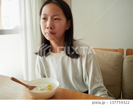 家の中に静かに食事をする十代の子供の姿	 137754322