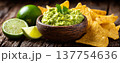 Guacamole avocado tortilla chip lime mexican food snack dip salsa wooden bowl cilantro fresh guacamole dip with tortilla chip and lime rustic wood 137754636