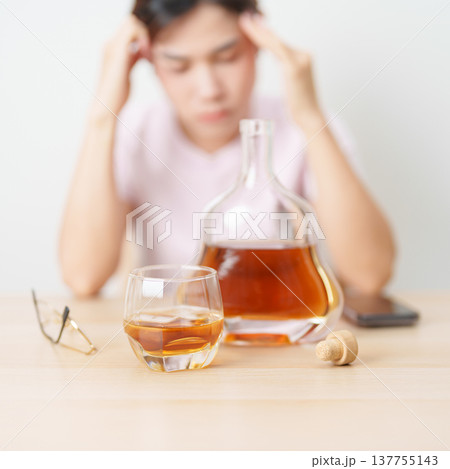 Stressed woman drinking cognac alone with problem. Exhausted drunk man looking stressed and sleepy. Alcohol addiction, Alcoholism, emotional distress and mental health concept Stressed woman drinking cognac alone with problem. Exhausted drunk man looking stressed and sleepy. Alcohol addiction, Alcoholism, emotional distress and mental health concept 137755143