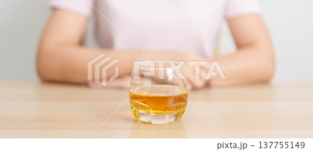 woman with glass of whiskey on table, suffering from alcohol addiction and alcoholism concept. depicting emotional distress, depression, substance abuse problem, unhealthy lifestyle and mental health woman with glass of whiskey on table, suffering from alcohol addiction and alcoholism concept. depicting emotional distress, depression, substance abuse problem, unhealthy lifestyle and mental health 137755149