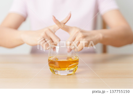 woman making stop hand gesture to refuse a glass of whiskey, Healthy man say no to alcohol drink, stop alcoholism and addiction concept. Responsible man reject a drink before driving and quit booze 137755150