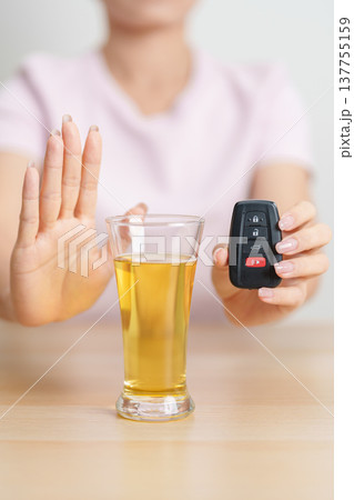 Responsible woman reject a drink before driving for road safety, Man making stop hand gesture to refuse a glass of Beer and car remote. Avoid drink and drive, Drunk Driving Law concept 137755159
