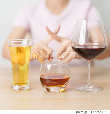 woman stop hand gesture to refuse a glass of wine, beer, whiskey or cognac on table. say no to alcohol drink, stop alcoholism addiction, Responsibility, reject a drink before drive and quit booze woman stop hand gesture to refuse a glass of wine, beer, whiskey or cognac on table. say no to alcohol drink, stop alcoholism addiction, Responsibility, reject a drink before drive and quit booze 137755162