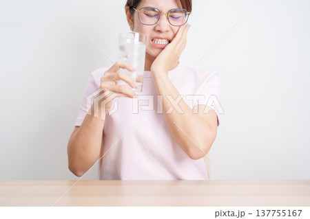 woman having toothache and pain after drink ice water for concept of Teeth Sensitive to Cold, Tooth Decay and Gum Disease, Grinding Teeth and Stress, Exposed Nerve Roots, Crack and Receding woman having toothache and pain after drink ice water for concept of Teeth Sensitive to Cold, Tooth Decay and Gum Disease, Grinding Teeth and Stress, Exposed Nerve Roots, Crack and Receding 137755167