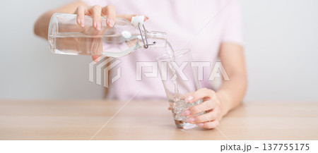 Healthy woman pour clean mineral water into glass at home, female drink pure water for hydration and wellness, fresh skin care, daily routine water intake, Refreshment and lifestyle concept Healthy woman pour clean mineral water into glass at home, female drink pure water for hydration and wellness, fresh skin care, daily routine water intake, Refreshment and lifestyle concept 137755175