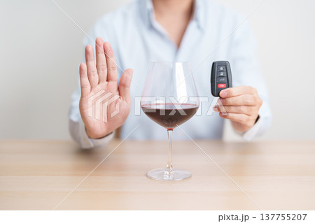 Responsible man reject a drink before driving for road safety, man making stop hand gesture to refuse a glass of Wine and car remote. Avoid drink and drive, Drunk Driving Law concept 137755207