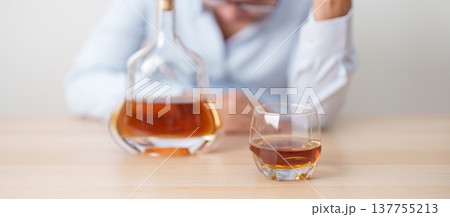 Stressed man drinking cognac alone with problem. Exhausted drunk man looking stressed and sleepy. Alcohol addiction, Alcoholism, emotional distress and mental health concept Stressed man drinking cognac alone with problem. Exhausted drunk man looking stressed and sleepy. Alcohol addiction, Alcoholism, emotional distress and mental health concept 137755213
