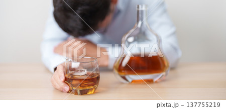 Stressed man drinking cognac alone with problem. Exhausted drunk man looking stressed and sleepy. Alcohol addiction, Alcoholism, emotional distress and mental health concept Stressed man drinking cognac alone with problem. Exhausted drunk man looking stressed and sleepy. Alcohol addiction, Alcoholism, emotional distress and mental health concept 137755219