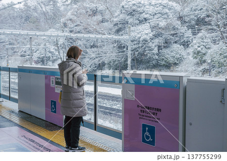 雪の日の王子駅ホーム　電車を待つ女性の後ろ姿 137755299