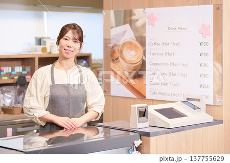 カウンターに立つ笑顔の女性カフェ店員 カウンターに立つ笑顔の女性カフェ店員 137755629