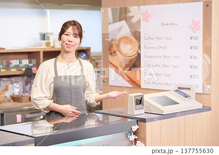 カウンターに立つ笑顔の女性カフェ店員 137755630