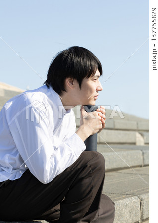 広場の階段で休憩する男性 137755829