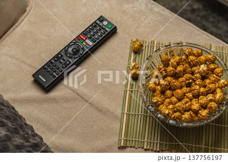 Enjoying popcorn and remote on a cozy couch during movie night 137756197