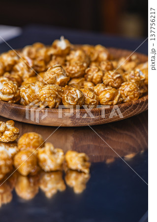 Sweet popcorn on wooden plate at evening gathering Sweet popcorn on wooden plate at evening gathering 137756217