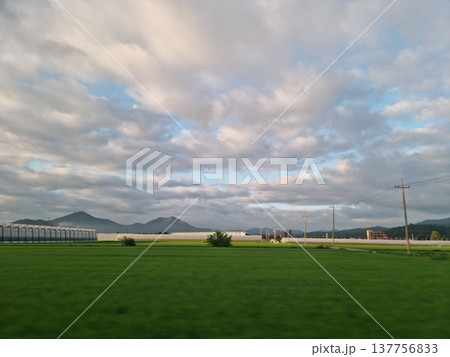 It is a rural landscape with a nice cloudy sky.	 137756833