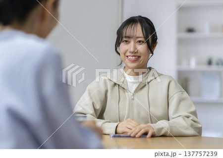 笑顔で話をする若い女性 137757239