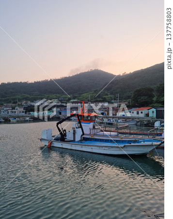 It is a landscape of an island village with fishing boats. It is a landscape of an island village with fishing boats. 137758803
