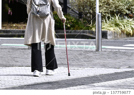 日本の横浜都市景観杖の高齢女性(マスク姿)、段差や傾斜のある歩道…人生とは…＝横浜市内 137759077