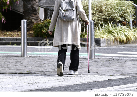 日本の横浜都市景観杖の高齢女性(マスク姿)、段差や傾斜のある歩道…人生とは…＝横浜市内 137759078