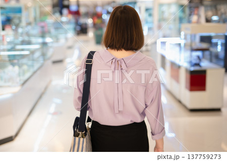 backside of short hair asian woman shopping at mall during sale and discount with wear protective mask backside of short hair asian woman shopping at mall during sale and discount with wear protective mask 137759273