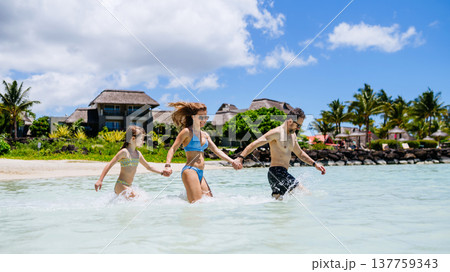 Family enjoying tropical beach vacation at luxury resort. 137759343