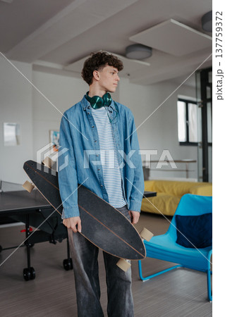 High school student with skateboard in hands. High school student with skateboard in hands. 137759372