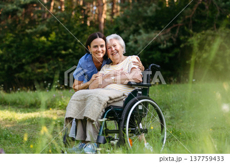 Home nurse taking care of elderly woman in wheelchair. Home nurse taking care of elderly woman in wheelchair. 137759433