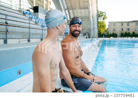 Older swimmer giving younger athlet advice before competition. 137759481
