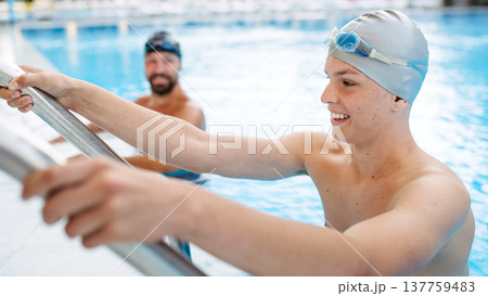 Father and teenage son enjoying swim training together. 137759483