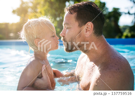 Father playing with little son in pool. Father playing with little son in pool. 137759516
