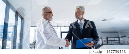Portrait of manager shaking hand with doctor. Banner with copy space. 137759528