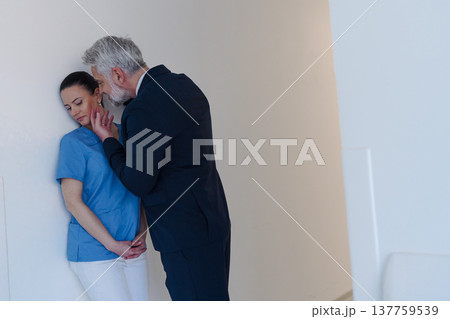 Hospital manager harassing attractive nurse in healthcare setting. Hospital manager harassing attractive nurse in healthcare setting. 137759539