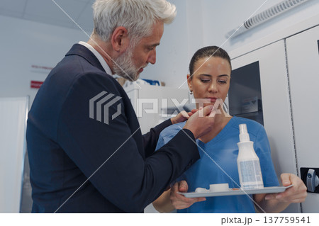 Hospital manager harassing attractive nurse in healthcare setting. 137759541