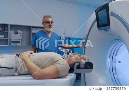Doctor operationg CT machine in hospital. Doctor operationg CT machine in hospital. 137759579