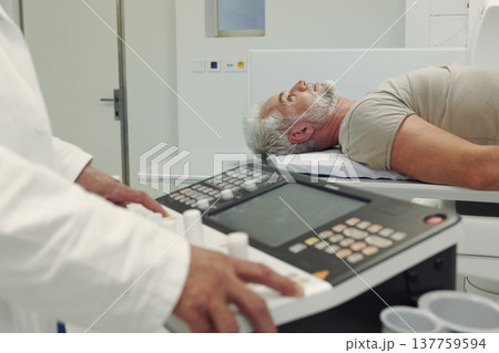 Doctor operationg CT machine in hospital. Doctor operationg CT machine in hospital. 137759594