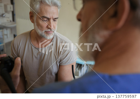 Doctor explaining colonoscopy results to patient using monitor images. Doctor explaining colonoscopy results to patient using monitor images. 137759597