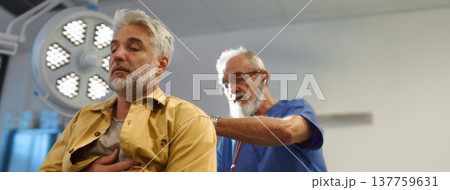 Doctor examining patient, listening to breathing with stethoscope. 137759631