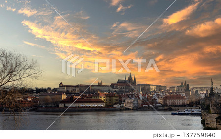 24 Feb 2026, Prague,Czech Republic. Stunning sunset view of Prague Castle and Vltava River in Prague, Czech Republic. Beautiful golden sky over the historic European city skyline at dusk 137759840