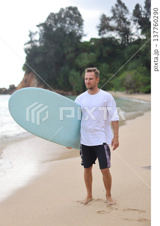 Tropical Beach Surfing Coaching Image. Surfer Trainer Standing With Board On Vibrant Tropical Coast Tropical Beach Surfing Coaching Image. Surfer Trainer Standing With Board On Vibrant Tropical Coast 137760290