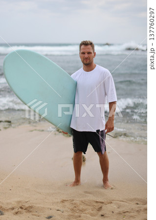 Full Body Shot Of Man At Seaside. Relaxed Individual In White Shirt With Surfboard On Sandy Coast 137760297