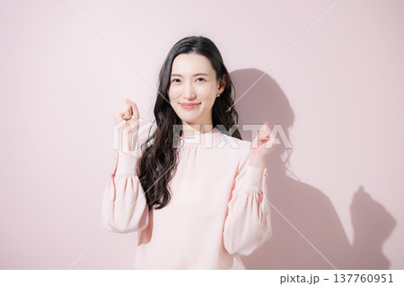 ガッツポーズで多幸感あふれる春色ビジネスイメージ　2026トレンドカラーピンク 137760951