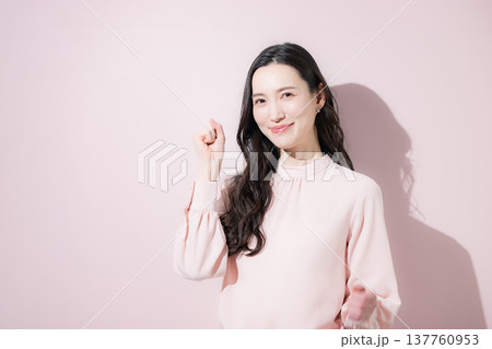 ガッツポーズで多幸感あふれる春色ビジネスイメージ　2026トレンドカラーピンク 137760953