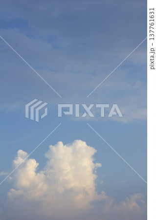 It is a sunset sky with puffy clouds. It is a sunset sky with puffy clouds. 137761631